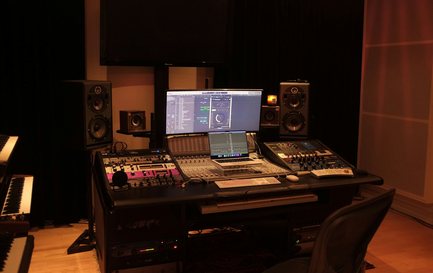 Una moderna scrivania da studio di registrazione musicale con apparecchiature audio e computer.